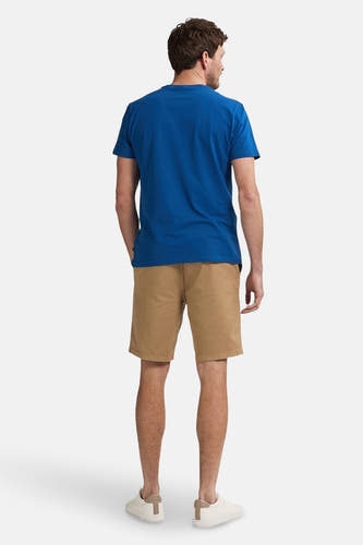 Beige court de Petrol Industries, avec un design uni, combiné à un t-shirt bleu et des baskets blanches.
