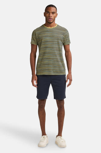 Blauwe short van Petrol Industries, gedragen met een gestreept T-shirt en witte sneakers.
