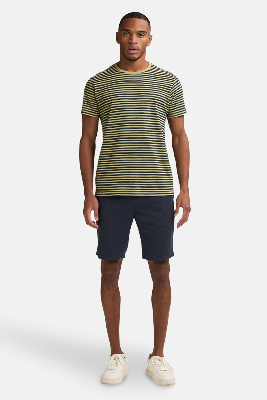 Blauwe short van Petrol Industries, gedragen met een gestreept T-shirt en witte sneakers.