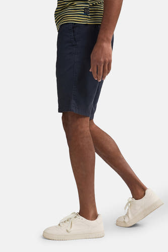 Blauwe short van Petrol Industries, met een gestreept shirt en witte sneakers, in zij-aanzicht.
