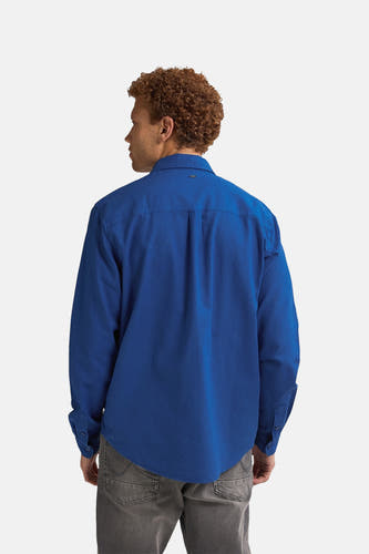 Chemise bleue à manches longues de Petrol Industries®, envers visible, associée à des jeans gris.
