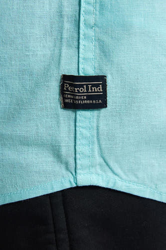 Chemise turquoise à manches courtes de Petrol Industries, avec un tissu texturé et une étiquette.