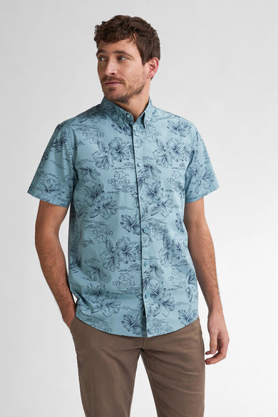 Chemise bleue à manches courtes de Petrol Industries®, avec imprimé fleuri et pantalon marron.