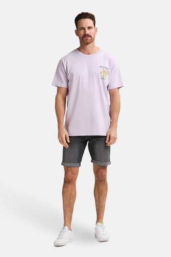 Man in lila T-shirt, grijze korte broek en witte sneakers.