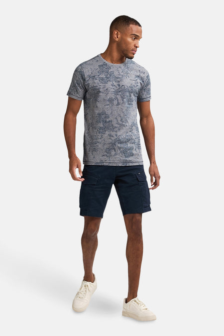 T-shirt bleu à manches courtes de Petrol Industries, avec un motif subtil et porté avec des pantalons cargo.