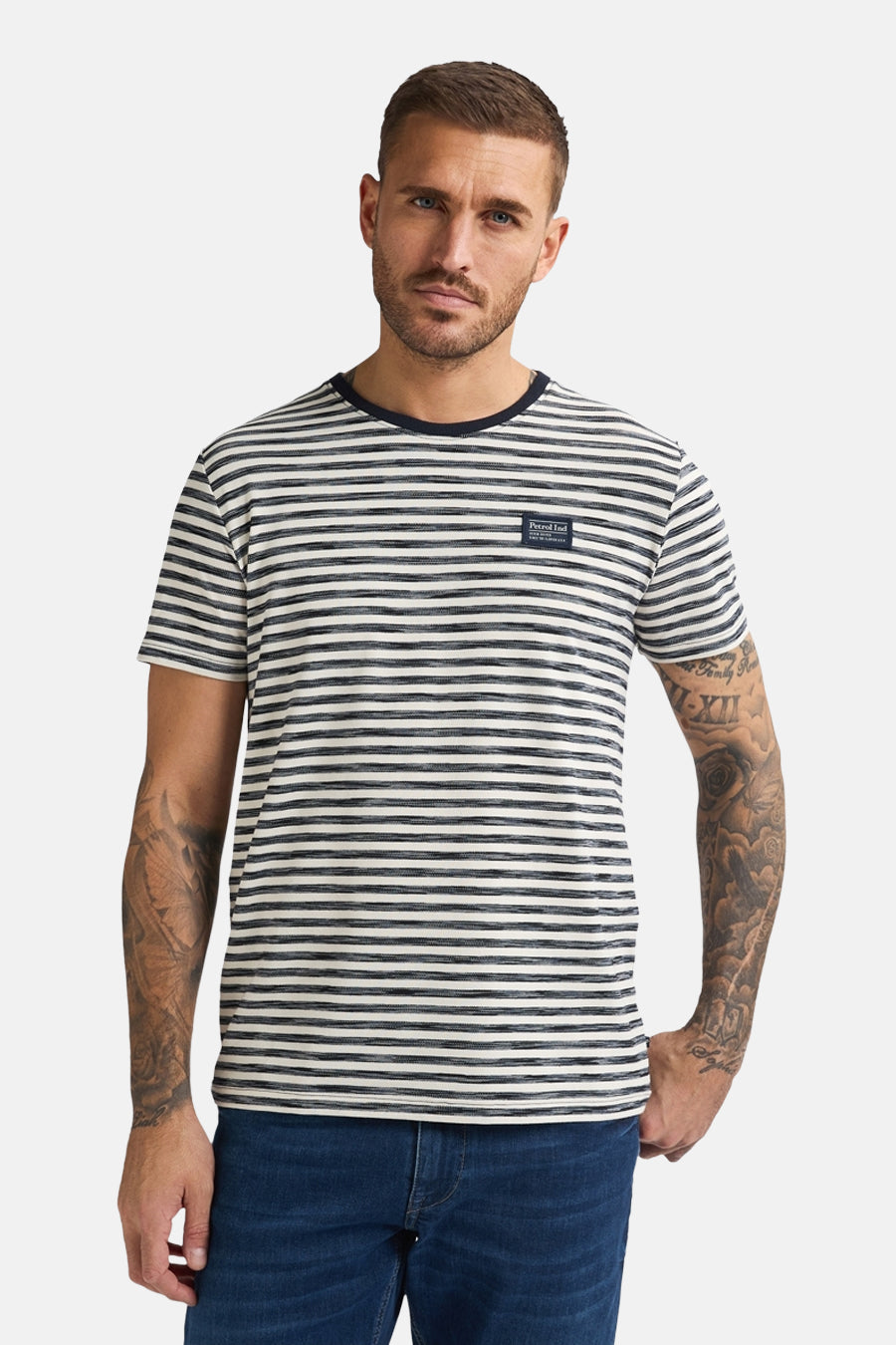 Een man met een gestreept T-shirt en blauwe jeans.