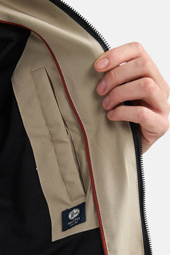 Manteau court beige de Petrol Industries, avec une doublure intérieure en mesh et une bande d'accent rouge.