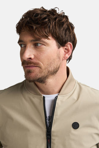 Veste courte beige de Petrol Industries®, avec fermeture à glissière et badge rond sur la poitrine.
