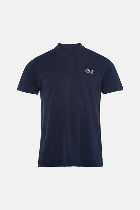 Polo bleu à manches courtes de Petrol Industries, porté avec un jean déchiré et des baskets blanches.