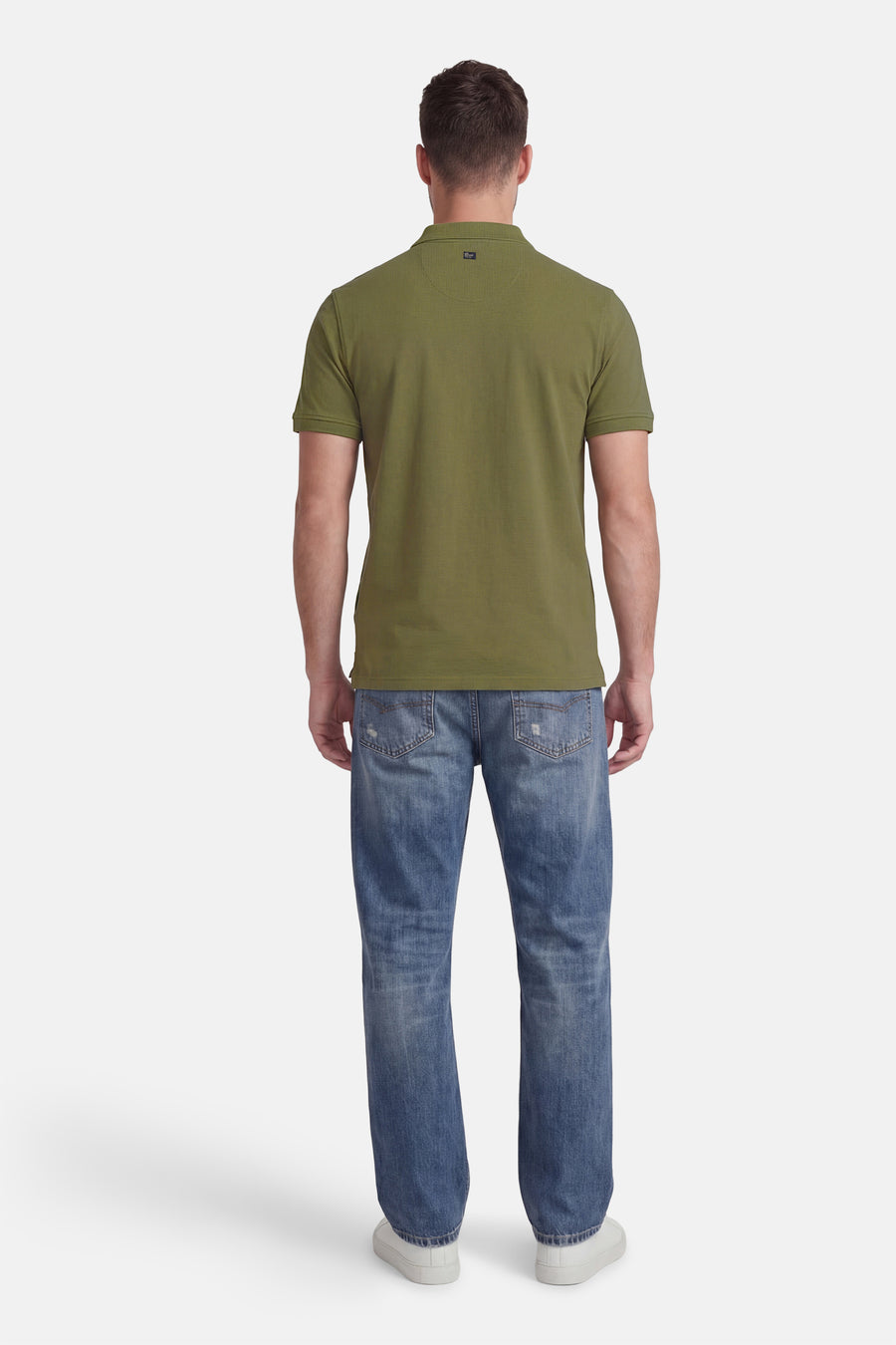 Polo verte de Petrol Industries, à manches courtes, portée avec un jean bleu et des baskets blanches, vue de dos.