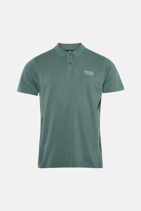 Polo verte de Petrol Industries à manches courtes avec un logo sur la poitrine, portée avec un jean clair et des baskets.