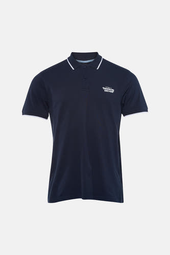 Polo bleu à manches courtes de Petrol Industries®, avec des accents blancs sur le col et les manches, combinée avec un jean et des chaussures blanches, dos.