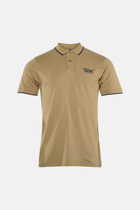 Polo à manches courtes de Petrol Industries, avec logo sur la poitrine, combinée avec un jean déchiré.
