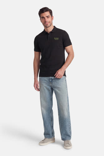 Zwarte polo met korte mouwen van Petrol Industries, met een subtiel logo op de borst, gedragen met jeans en sneakers.