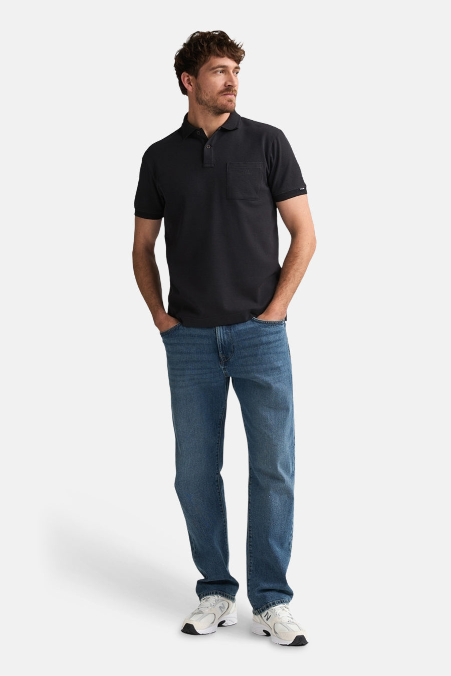 Polo noire de Petrol Industries®, à manches courtes et avec une poche poitrine, à combiner avec un jean et des baskets blanches.