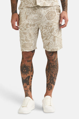 Short beige de Petrol Industries® à motif cachemire, combiné avec une chemise assortie et des chaussures blanches, vu de dos.