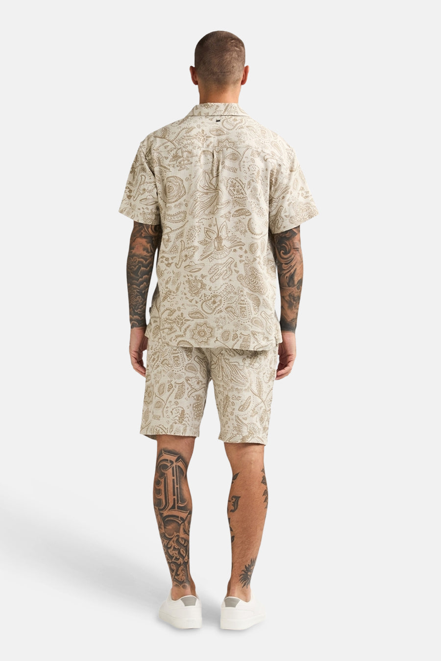 Beige short van Petrol Industries® met paisley-patroon, gecombineerd met een bijpassend overhemd en witte schoenen, van achteren gezien.