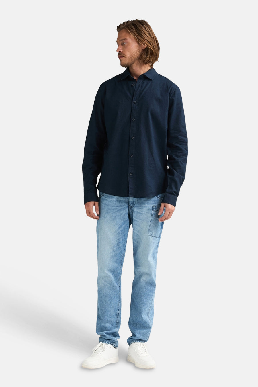 Chemise bleue à manches longues de Petrol Industries®, portée avec un jean et des baskets blanches.