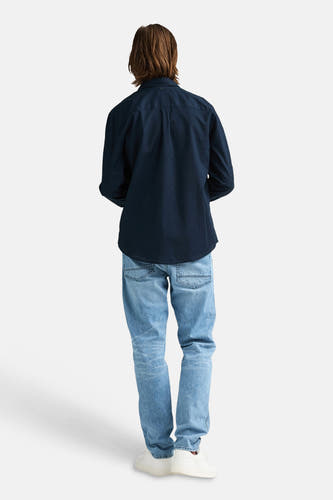Blauw overhemd met lange mouwen van Petrol Industries®, gezien van achteren, met lichtblauwe jeans en witte sneakers.
