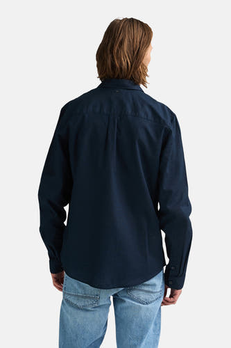 Chemise bleue à manches longues de Petrol Industries, vue de dos, portée avec un jean.