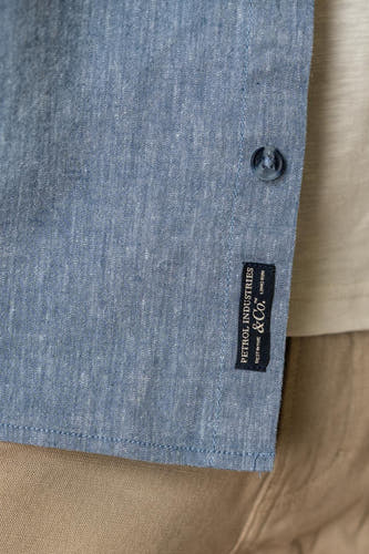 Chemise bleue à manches courtes de Petrol Industries, avec une étiquette sur la poitrine et un bouton.