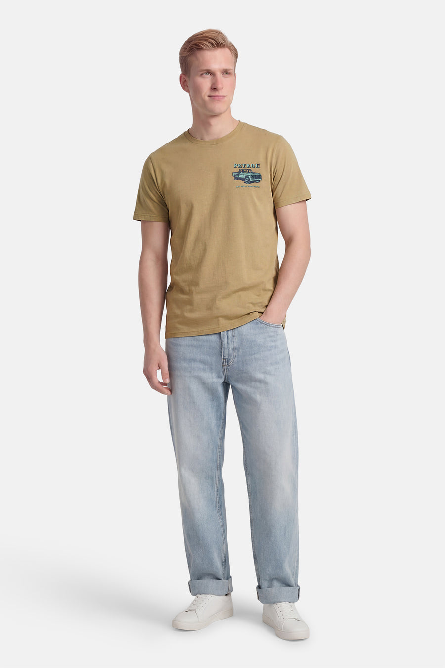 T-shirt vert à manches courtes de Petrol Industries®, avec un imprimé graphique sur la poitrine et porté avec un jean bleu.