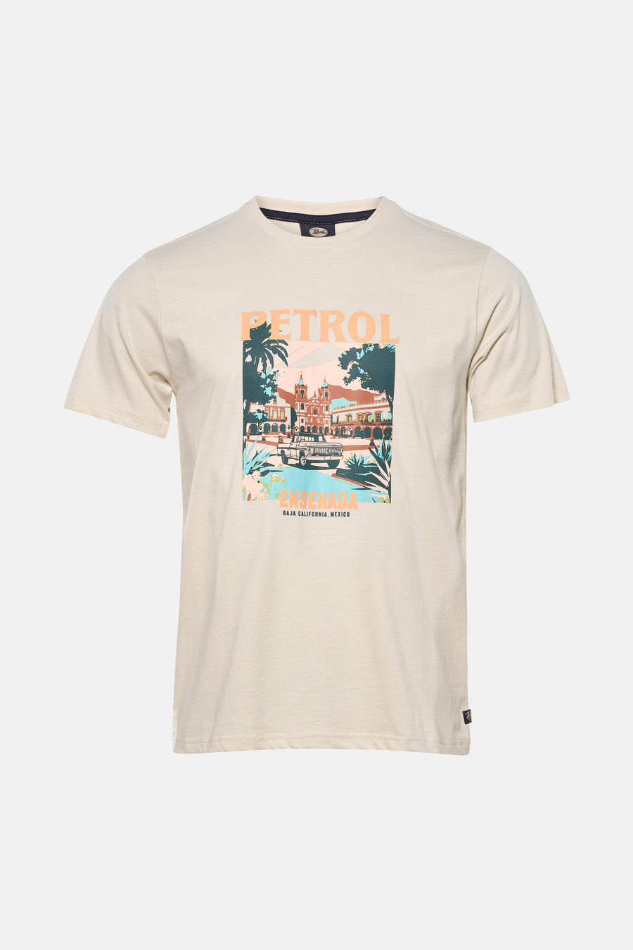 T-shirt écru à manches courtes de Petrol Industries®, avec un imprimé graphique sur le devant et porté avec un jean gris et des chaussures marron.