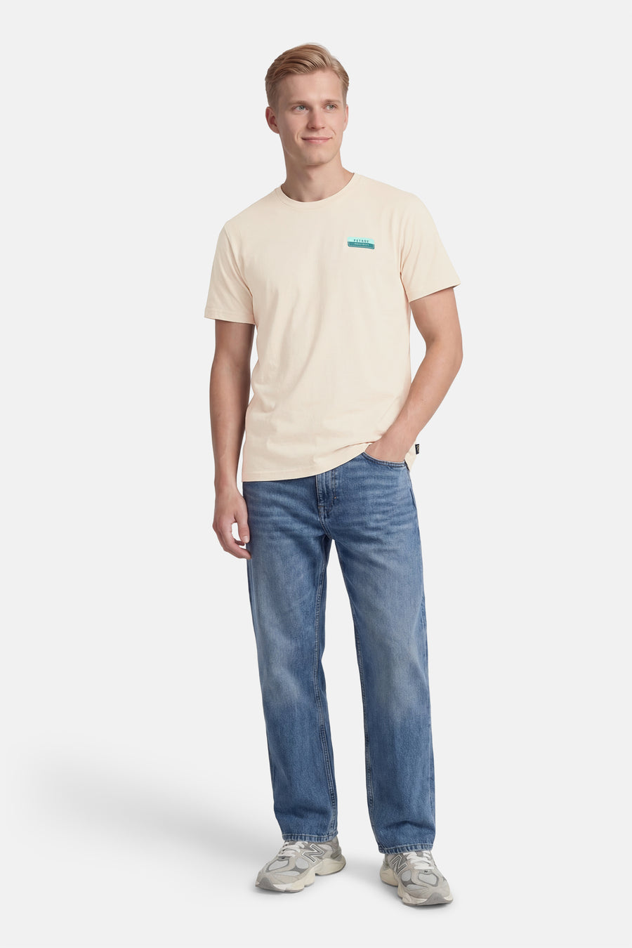 Ecru T-shirt met korte mouwen van Petrol Industries, met logo op de borst, gedragen met blauwe jeans en sneakers.
