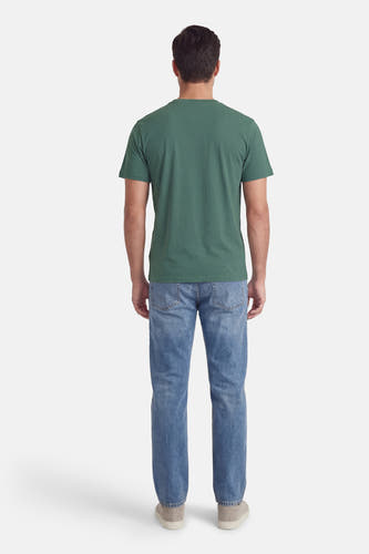T-shirt vert à manches courtes de Petrol Industries®, avec un motif uni et porté avec un jean bleu et des chaussures en daim.