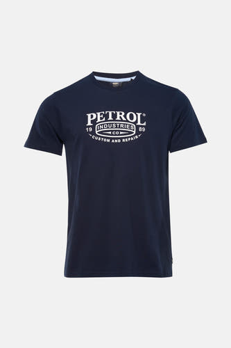 T-shirt bleu à manches courtes de Petrol Industries, avec imprimé blanc et combiné avec un jean clair et des baskets.