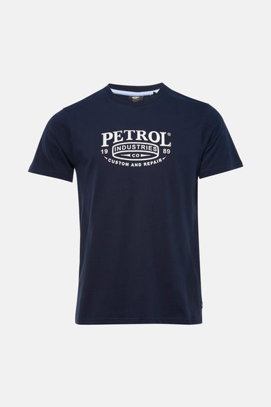 T-shirt bleu à manches courtes de Petrol Industries, avec imprimé blanc et combiné avec un jean clair et des baskets.