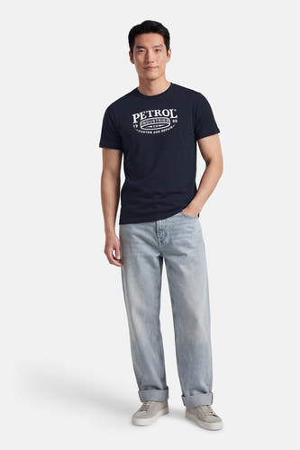 Blauw T-shirt met korte mouwen van Petrol Industries, met witte opdruk en gecombineerd met lichte jeans en sneakers.