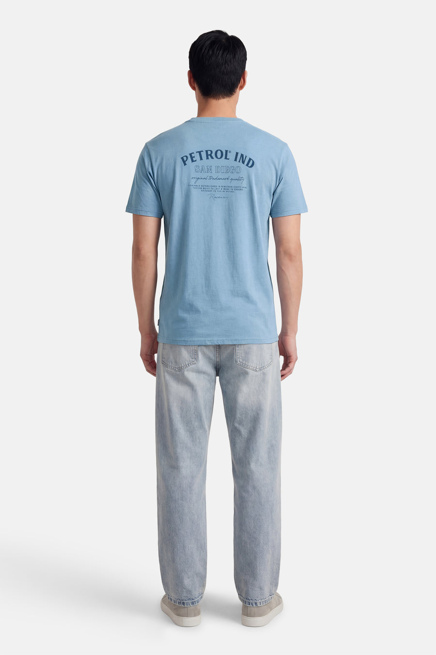 Blauw T-shirt met korte mouwen van Petrol Industries, met tekstprint op de achterkant, gecombineerd met een lichtblauwe jeans.

