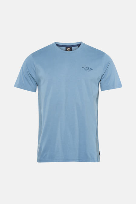 T-shirt bleu à manches courtes de Petrol Industries, avec imprimé texte au dos, combiné avec un jean bleu clair.