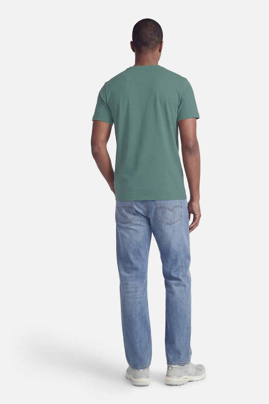 T-shirt vert à manches courtes de Petrol Industries, vu de dos, combiné avec un jean bleu et des baskets grises.