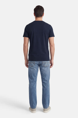 T-shirt bleu à manches courtes de Petrol Industries, vu de dos, avec un jean et des chaussures décontractées.