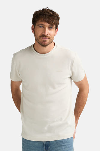 T-shirt écru à manches courtes de Petrol Industries, dos, combiné avec un jean bleu et des baskets blanches.