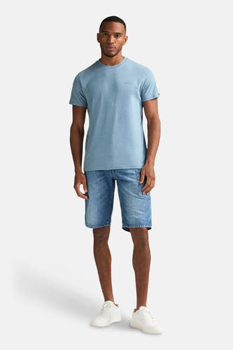 T-shirt bleu à manches courtes de Petrol Industries, porté avec un short en jean et des baskets blanches.