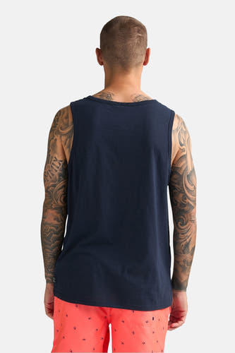 Débardeur bleu foncé de Petrol Industries®, porté par un homme tatoué avec un short orange à motifs, vu de dos.