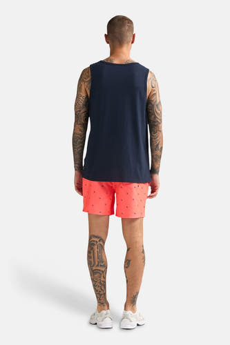 Blauw singlet van Petrol Industries, aan de achterkant getoond op een getatoeëerde man met koraalkleurige shorts en witte sneakers.