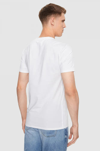 T-shirt blanc à manches courtes de Guess®, vu de l'arrière, avec des jeans bleus.