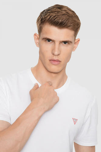 T-shirt blanc à manches courtes de Guess, avec un logo rouge sur la poitrine et une conception simple.