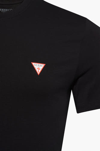 T-shirt noir de Guess avec des manches courtes et le logo sur la poitrine.