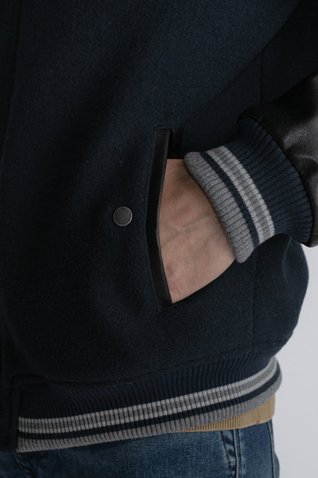 Veste bleue de Petrol Industries, avec des manches en cuir noir et des bordures rayées.