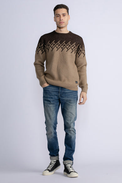 Pull marron avec col rond de Petrol Industries, avec un motif tissé sur la poitrine, associé à des jeans et des baskets.