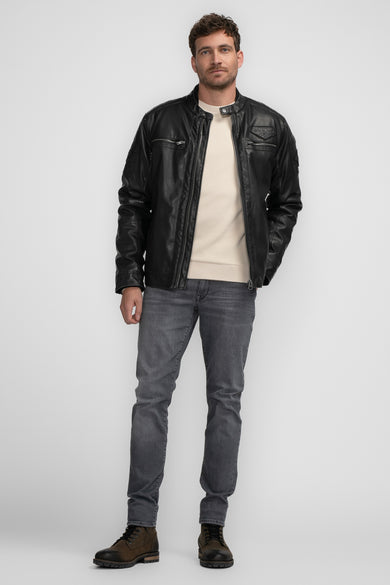 Manteau court noir de Petrol Industries, avec des jeans gris et des bottes militaires brunes.