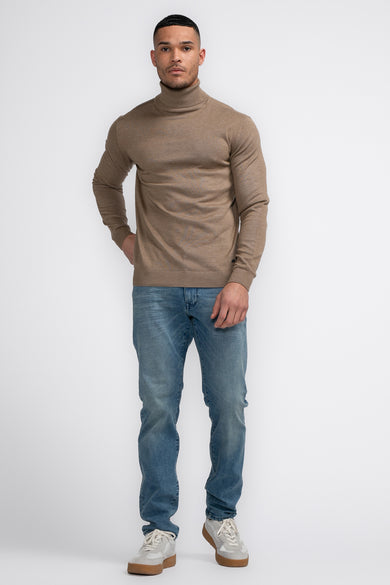 Veste à col montant beige de Petrol Industries®, portée avec des jeans bleus et des baskets blanches.