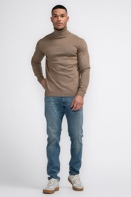 Veste à col montant beige de Petrol Industries®, portée avec des jeans bleus et des baskets blanches.