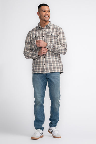 Blouse bleu marine à rayures avec des manches longues de Petrol Industries, portée avec des jeans et des baskets blanches.
