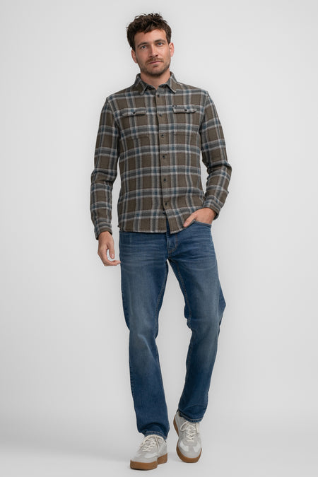 Chemise brune à longues manches de Petrol Industries, motif rayé, portée avec un jean bleu et des chaussures blanches.